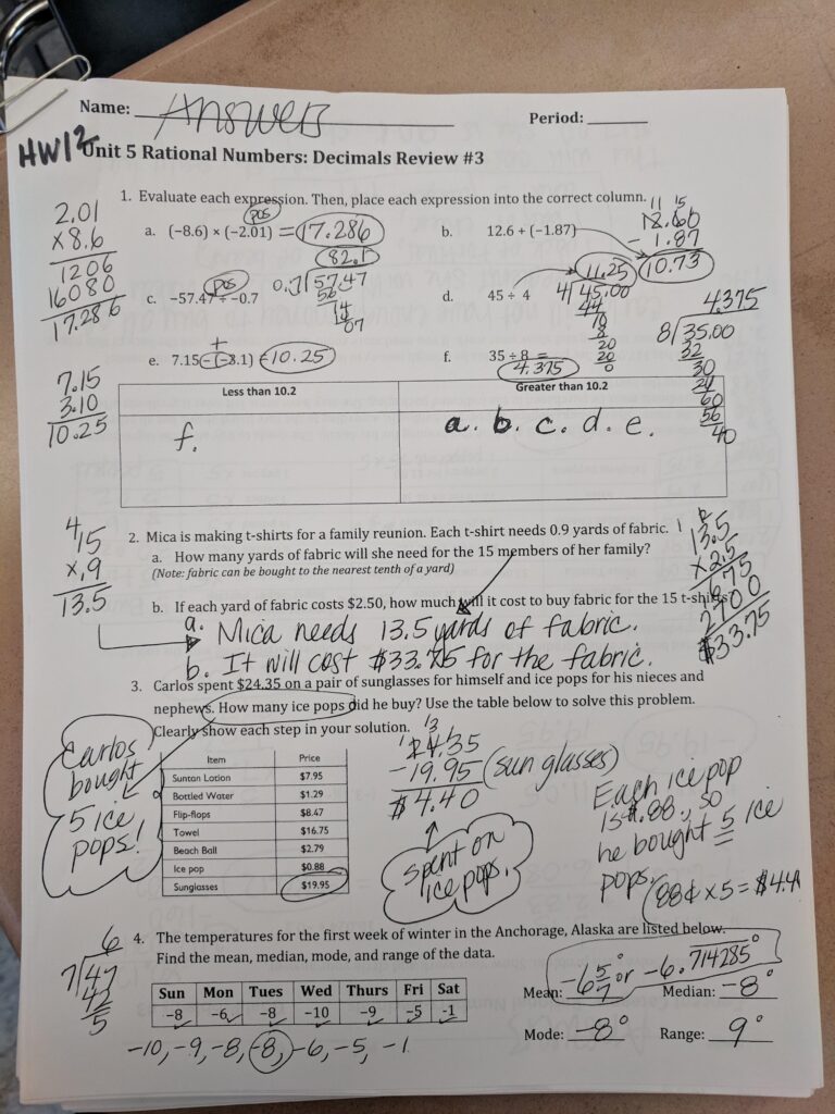 A completed rational-numbers review worksheet with handwritten answers and calculations for decimal operations, a fabric-cost word problem, ice-pop spending, and temperatures.
