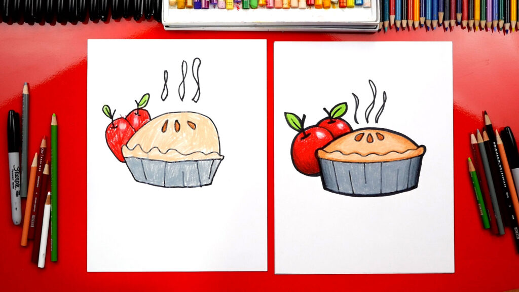 Two colored drawings of pies with apples and steam, shown on separate sheets of paper surrounded by pencils and markers.