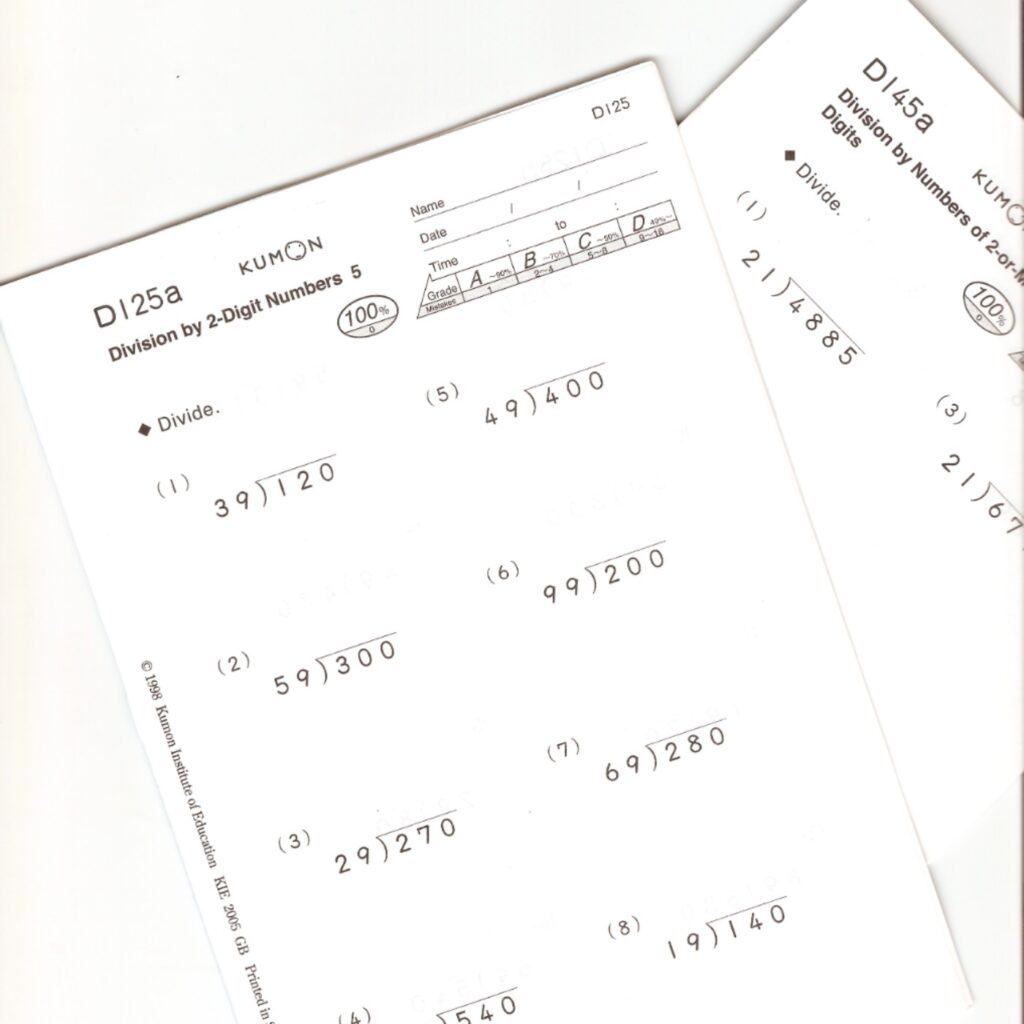 Two overlapping Kumon worksheets show long-division exercises with two-digit divisors, including problems such as 120 ÷ 39 and 400 ÷ 49.