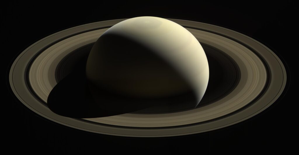Illustration of Saturn with broad, layered rings against a black background.